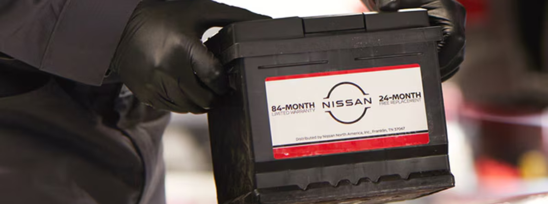 Close up on a battery being placed into a Nissan vehicle.